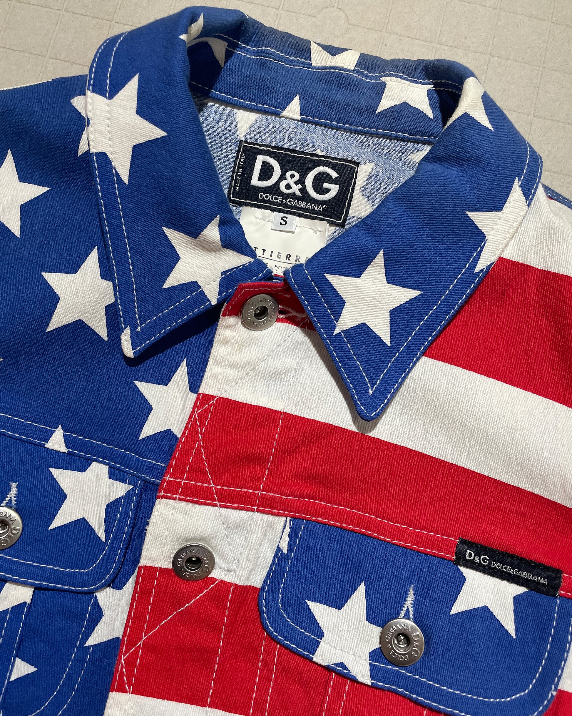 American flag patterned jacket with Dolce & Gabbana label on a neutral background